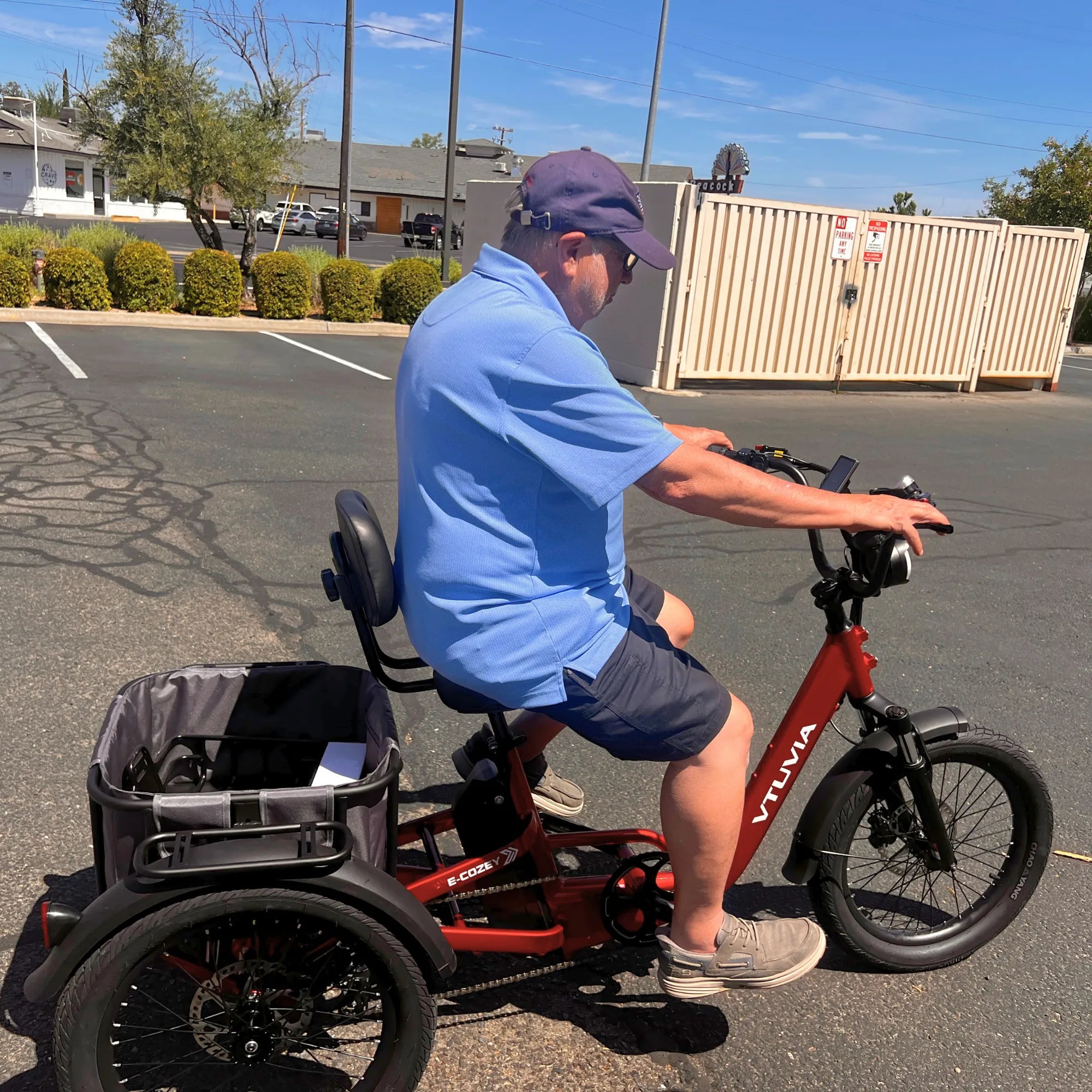 VTUVIA E-COZEY electric trike rider test ride showing comfortable seating position and rear cargo basket #color_ruby-red